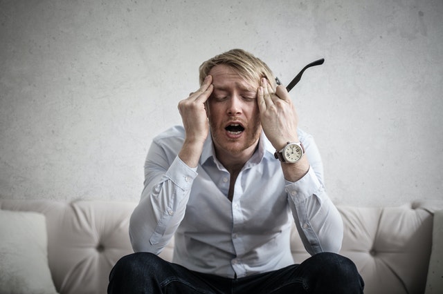 frustrated man sitting on a couch with no ac