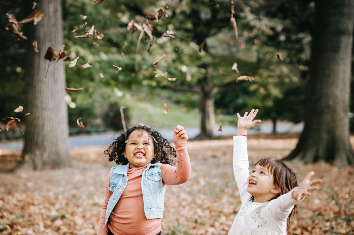 kids playing in fall leaves